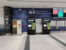 Máquinas de venda automática de bilhetes. Comboio UP Express à esquerda, autocarros à direita